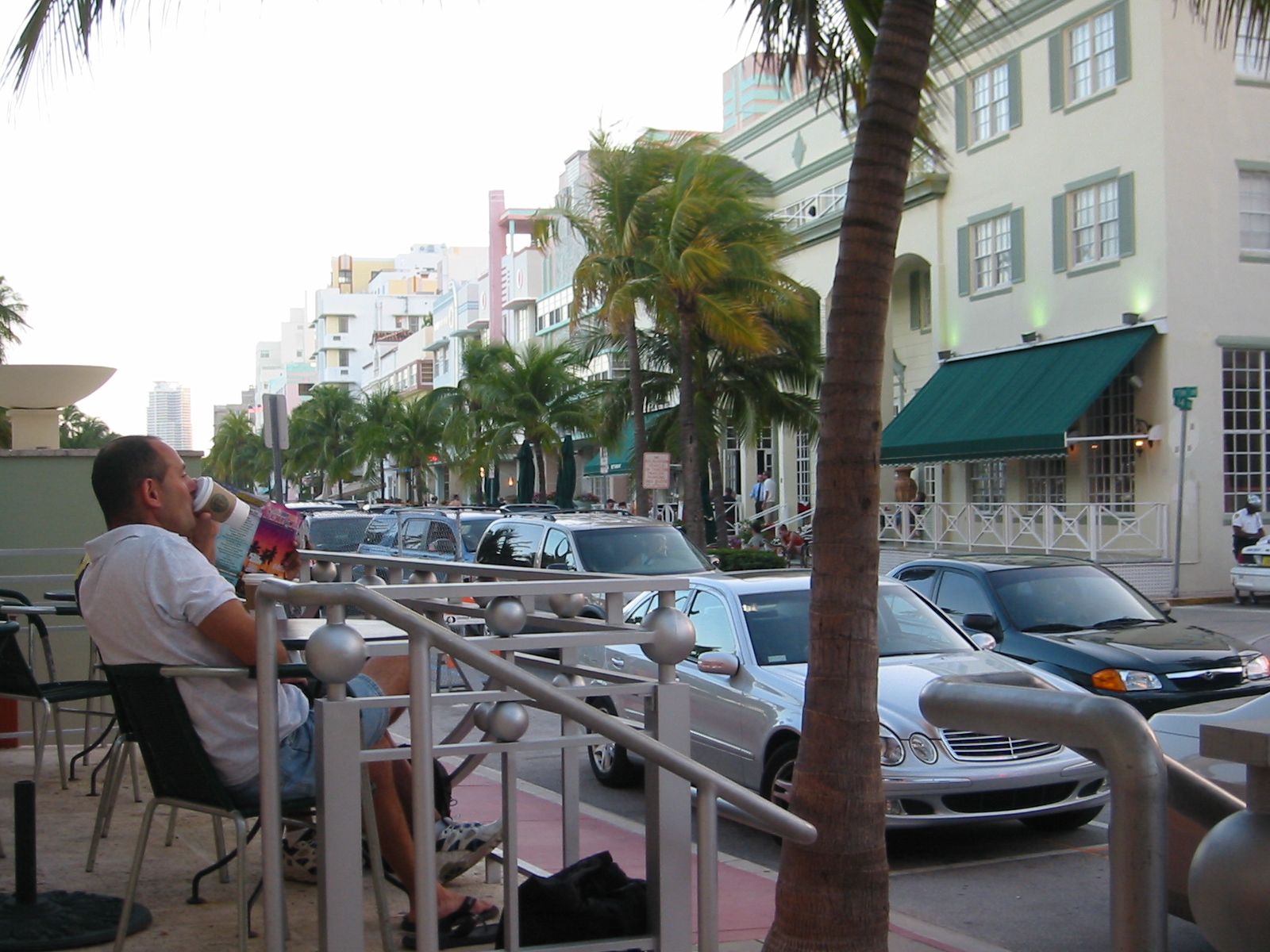 a man sits outside with his daughter and coffee in hand