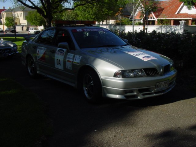 silver race car with number 11 on it parked in the street