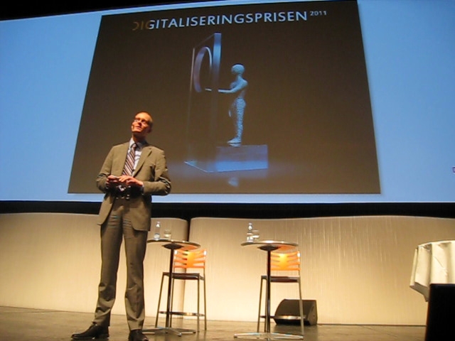 the man standing in front of a projector is giving his presentation