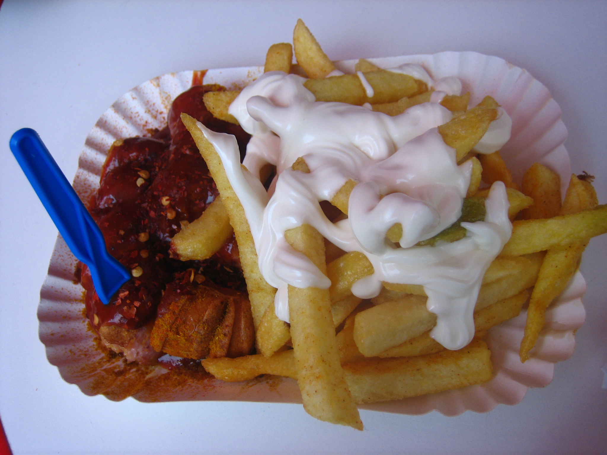 a plate of fries and condiments in paper