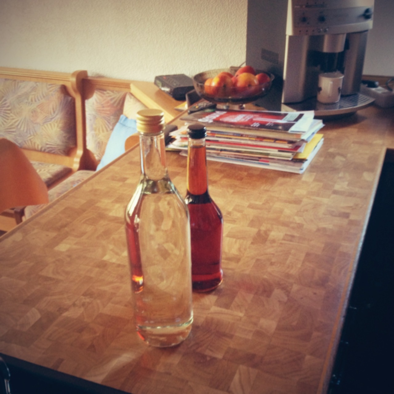 some bottles of oil and a glass bottle are sitting on the kitchen table