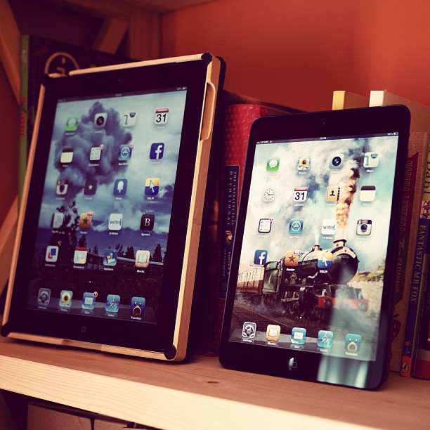 two ipads side by side, sitting on a shelf