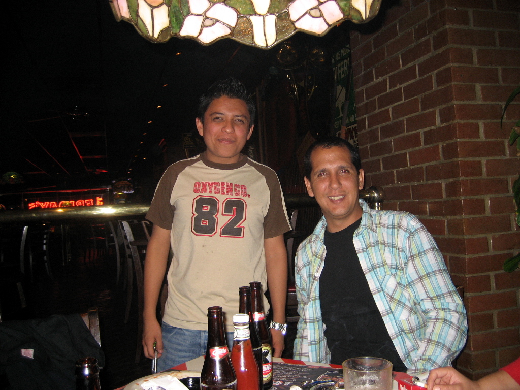 two men sitting at a table posing for the camera