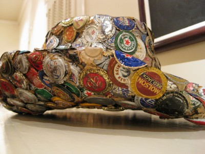 the small hat is decorated with many different bottle caps