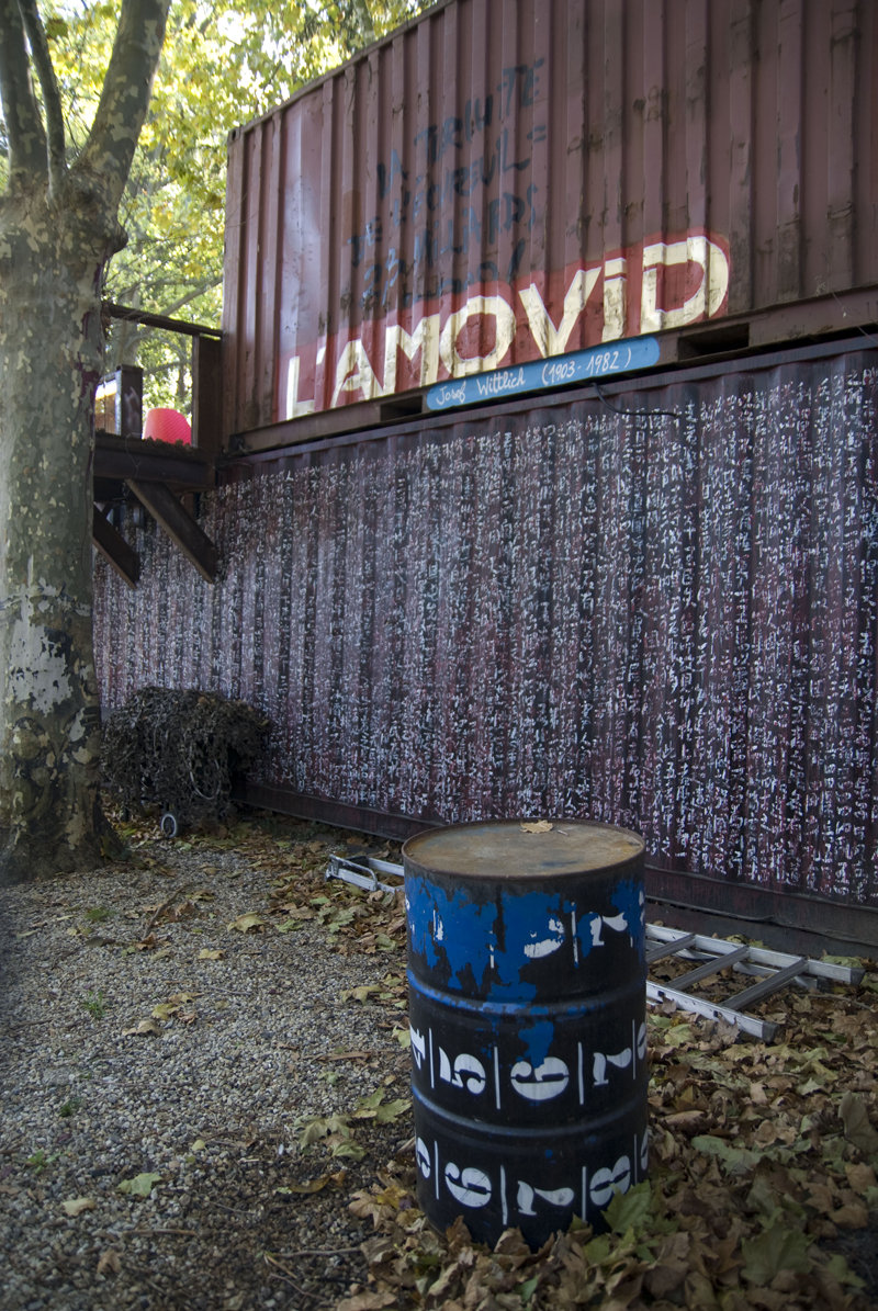 the large barrel on the ground near some trees