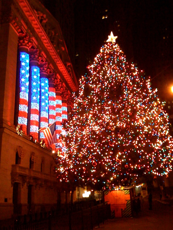 the christmas tree is lit with bright lights in front of a building