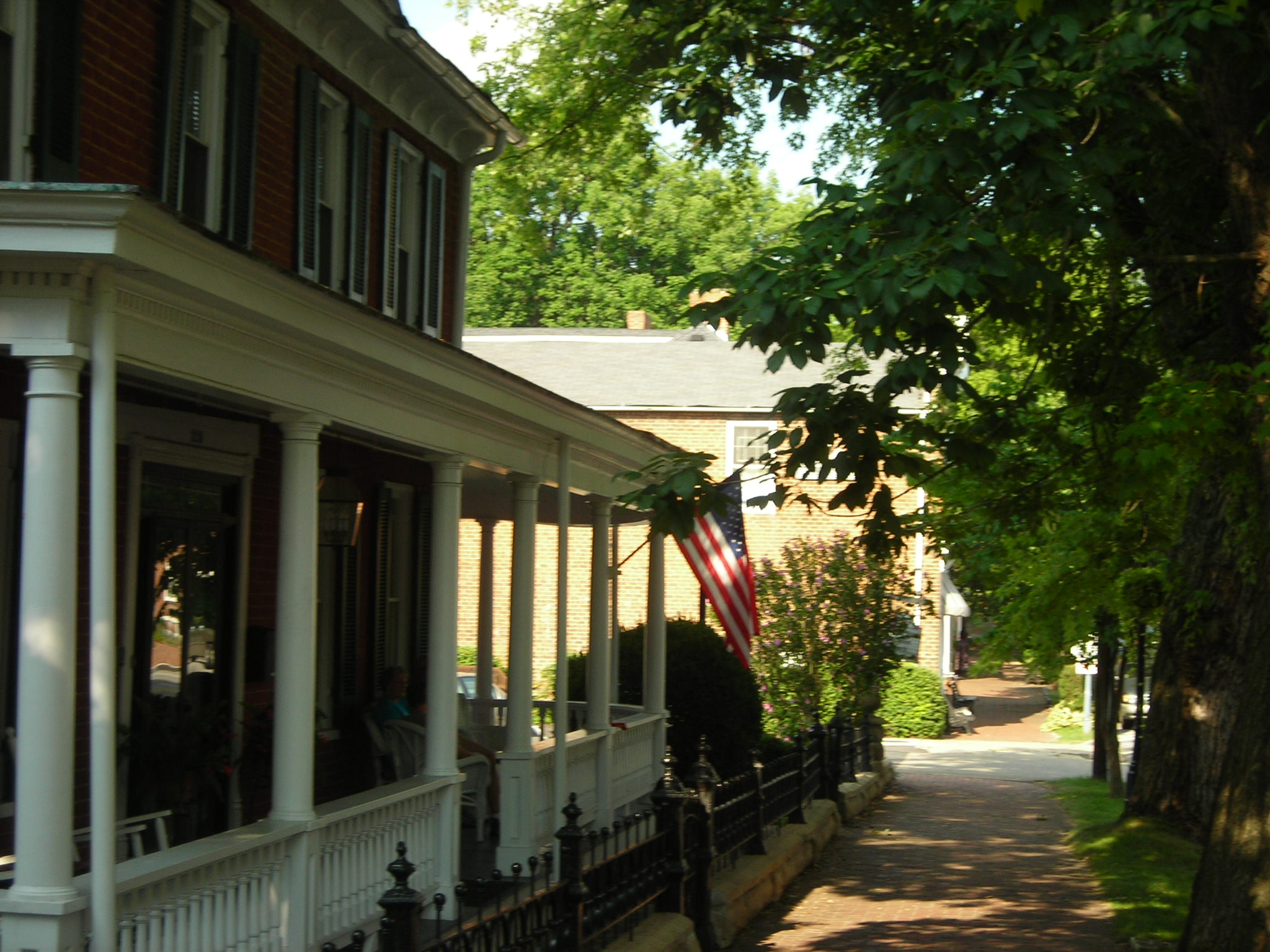 the front entrance to a colonial house and american flag in the window