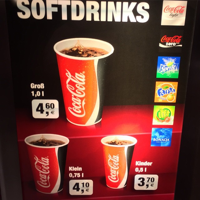 a vending machine with different cups and prices for sodas