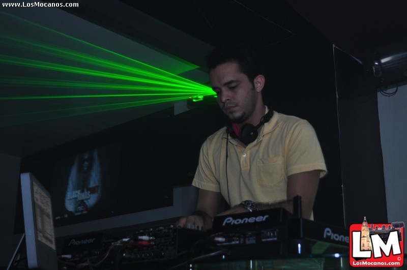 a dj standing at his turntable and mixing