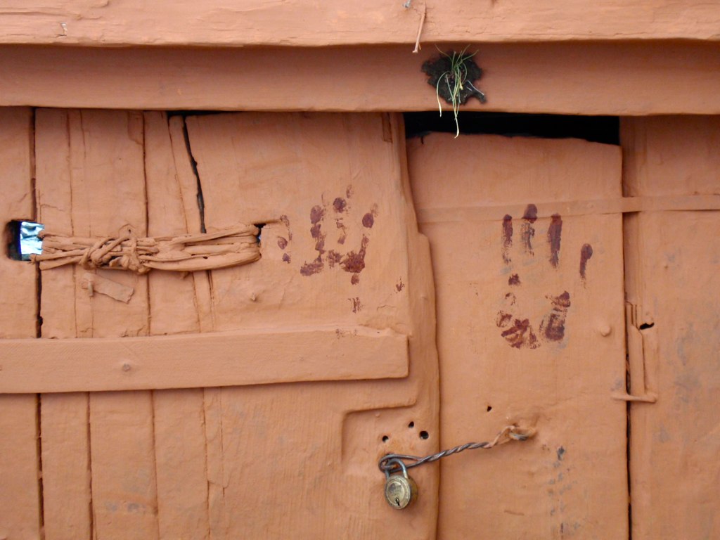 a wooden gate with several nails and a knot on it