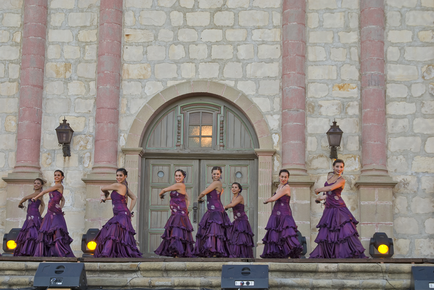 many women in dresses are standing outside the building