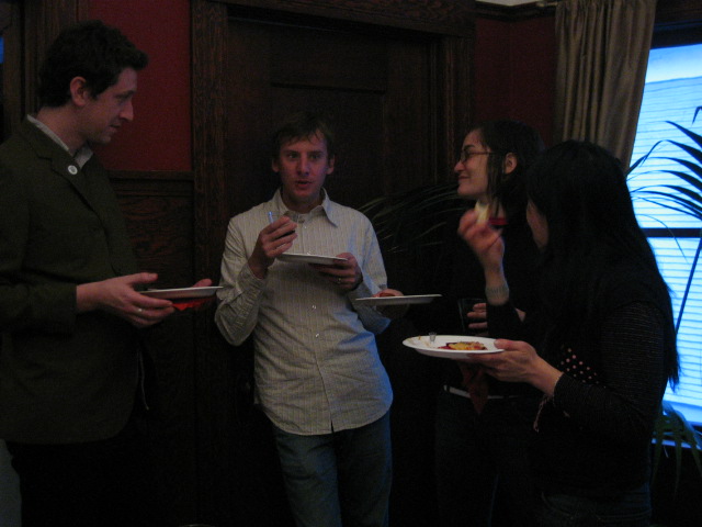 a group of people holding food and looking at papers