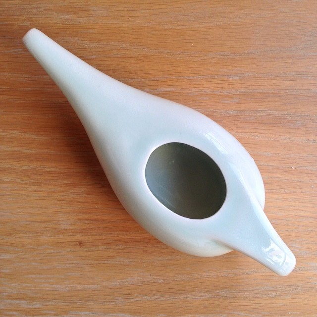 a porcelain tooth brush holder on a wooden surface