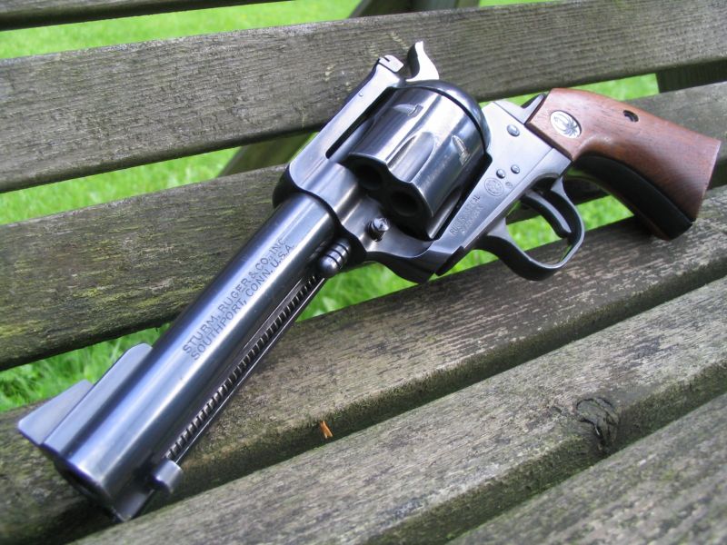 an old gun with a wooden grips sitting on a bench