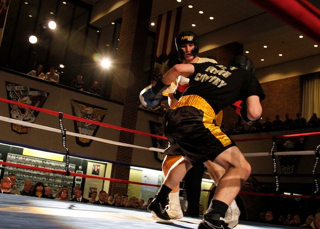 two boxers in yellow and black trunks during a boxing match