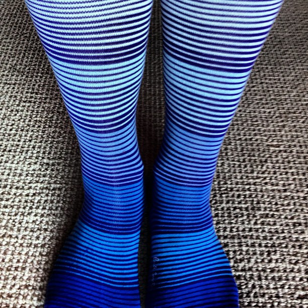 the bottom of a womans legs wearing blue striped socks