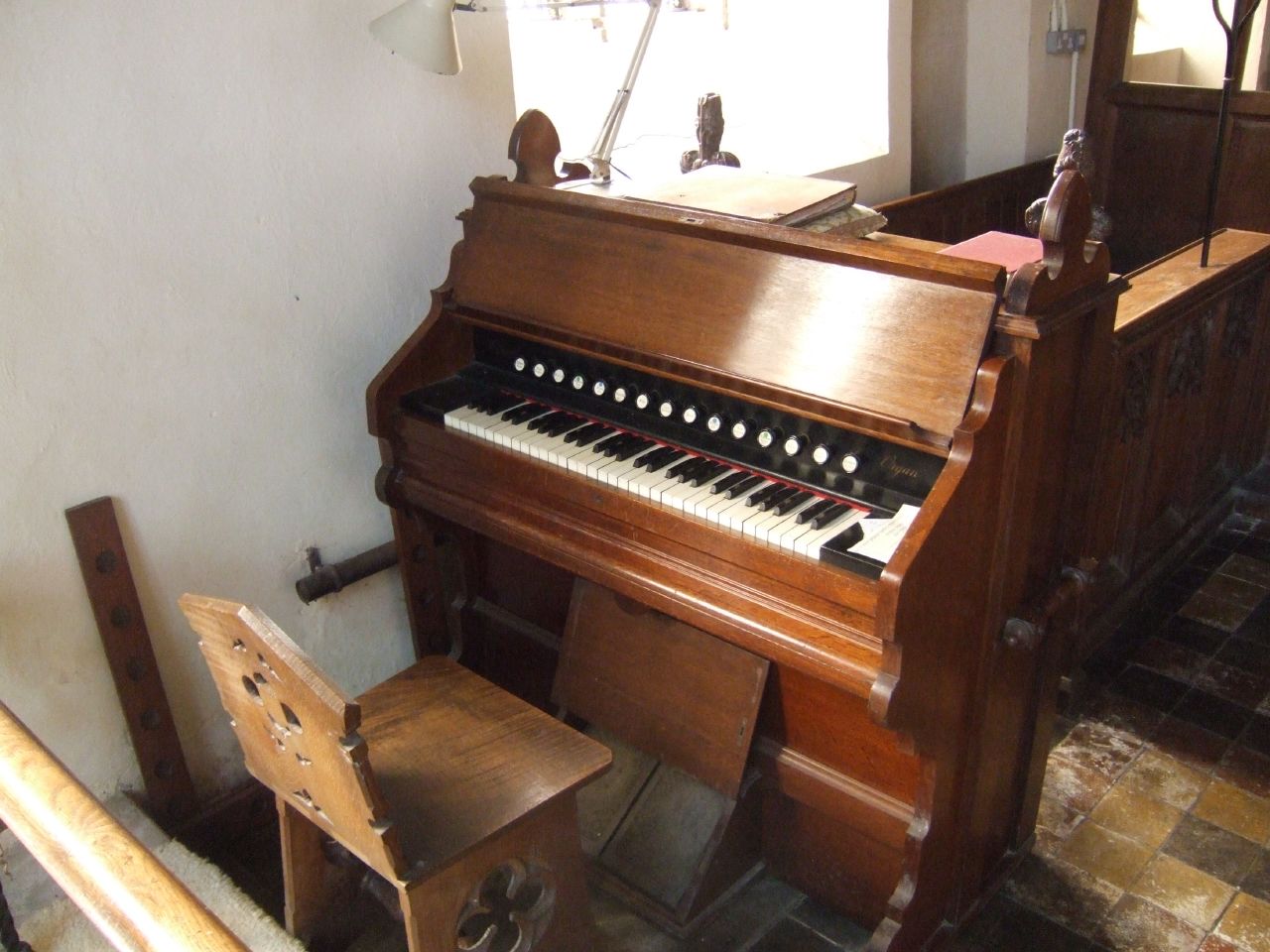 an old upright wooden piano in a church