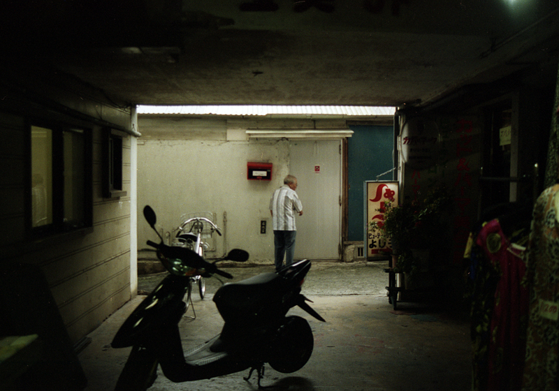 a person standing in a dark room next to a motorcycle