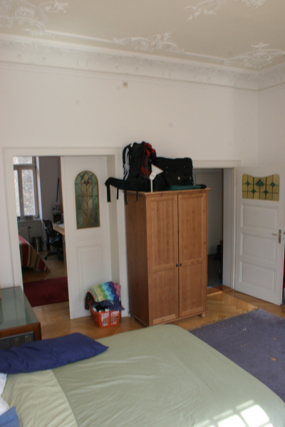 a white wall and cupboard with backpack on it