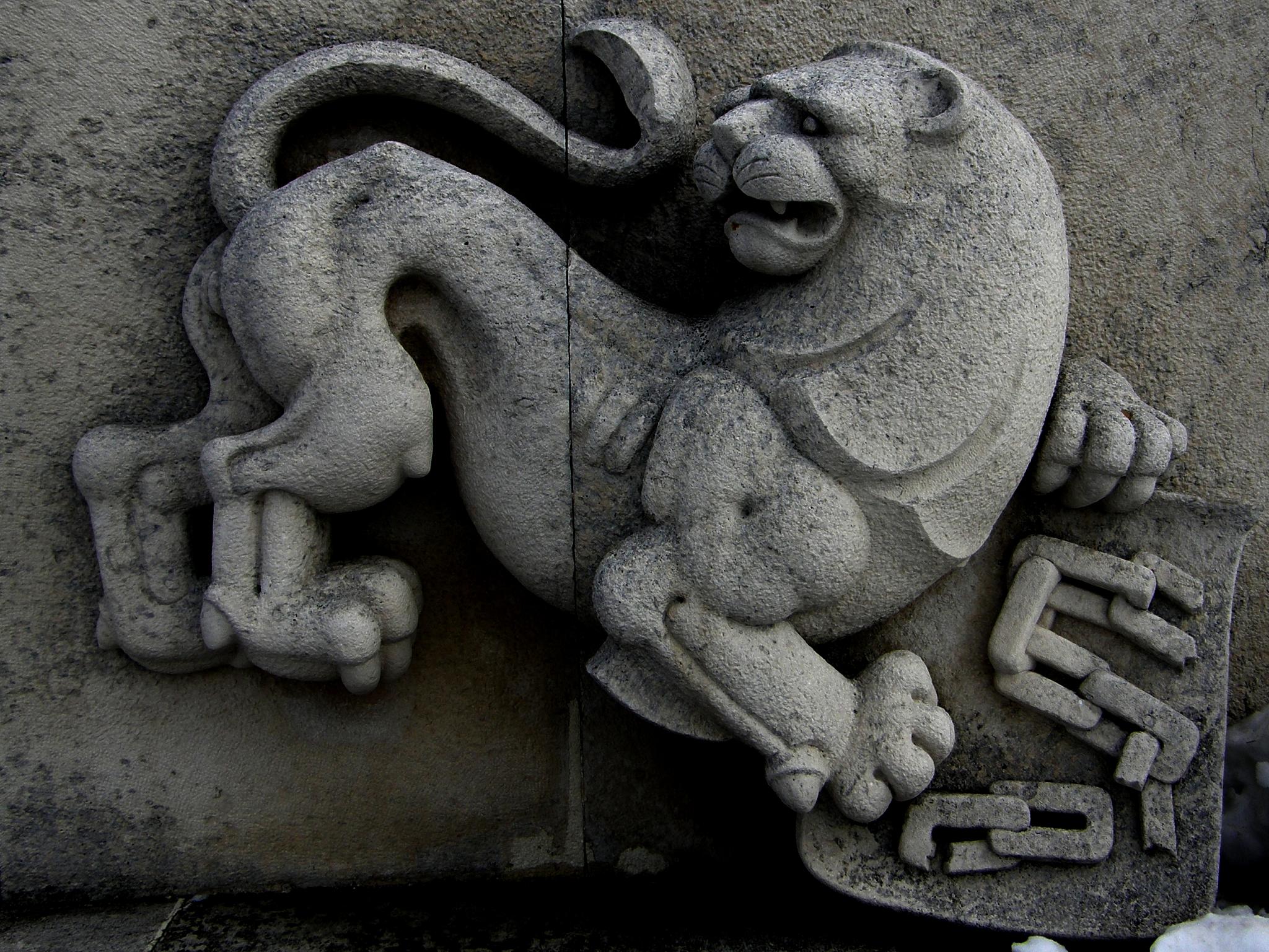 a stone animal statue is on the side of a building