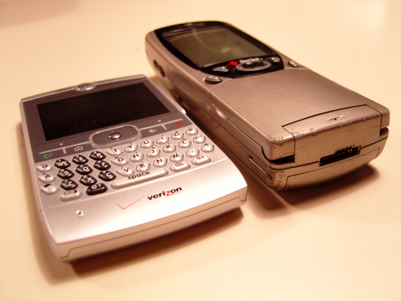 a flip phone with an older model cell phone on top