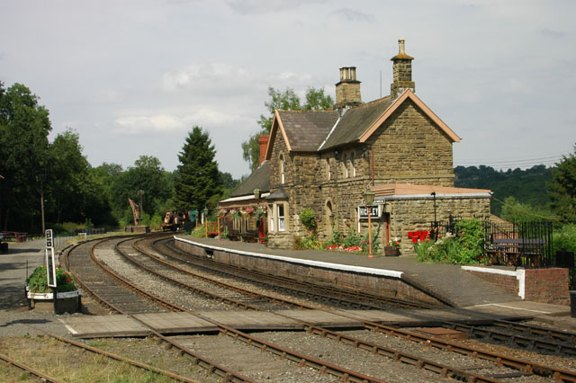 a train track with several small buildings and trees