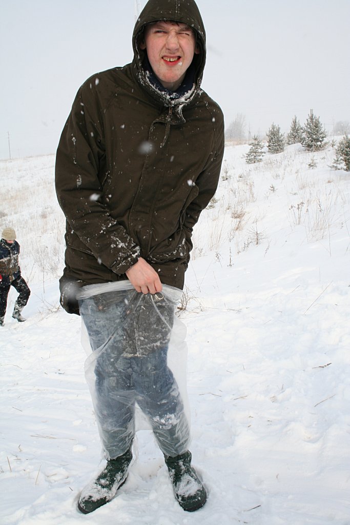 a young man standing outside on a snow covered hill