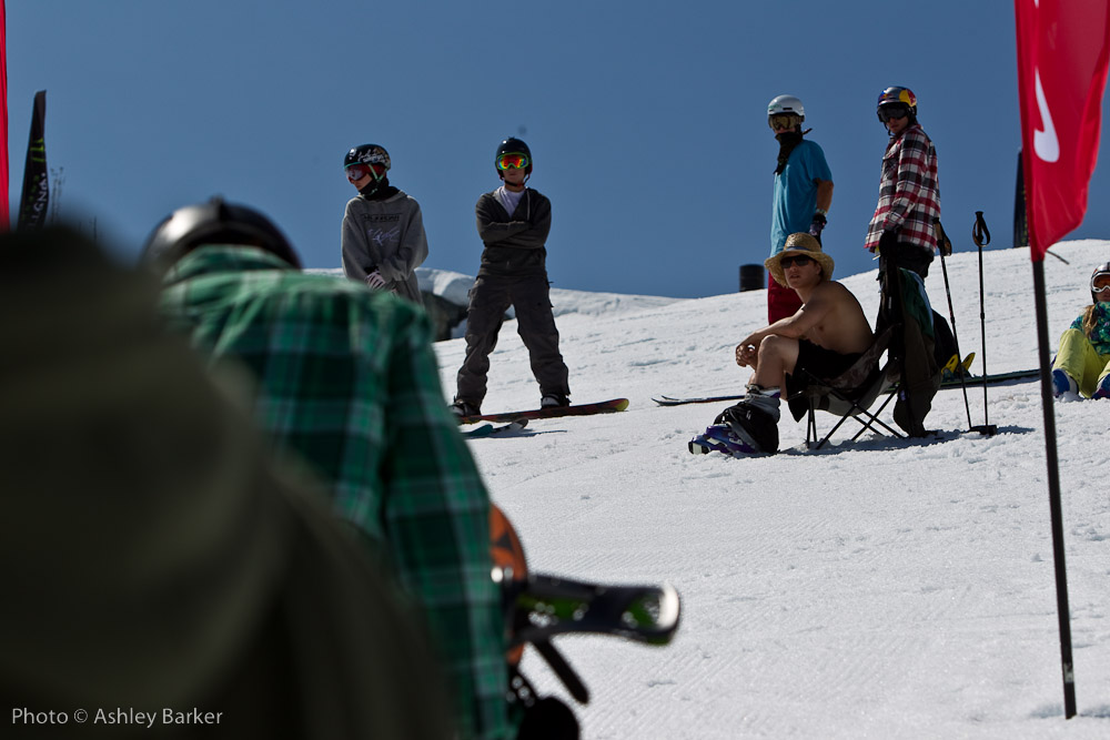 a group of snowboarders gathered together on a snowy hill