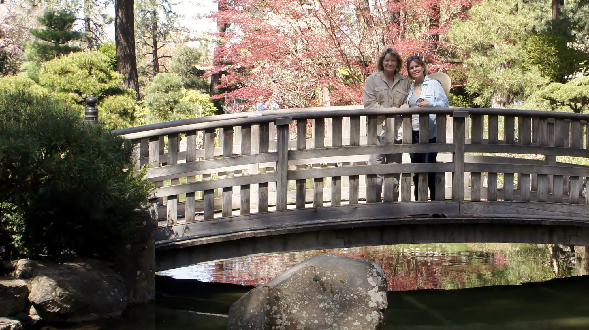 a woman and a man on a bridge over water