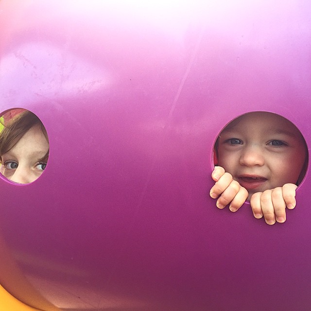 a girl peeks her head through a hole in a large ball