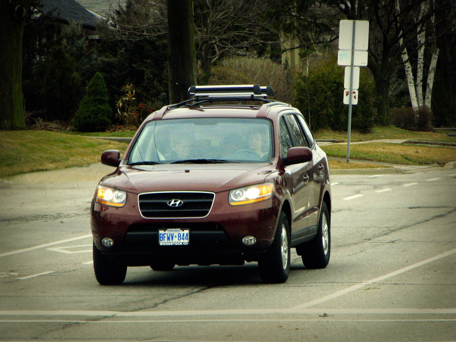 a car driving down the street with its light on