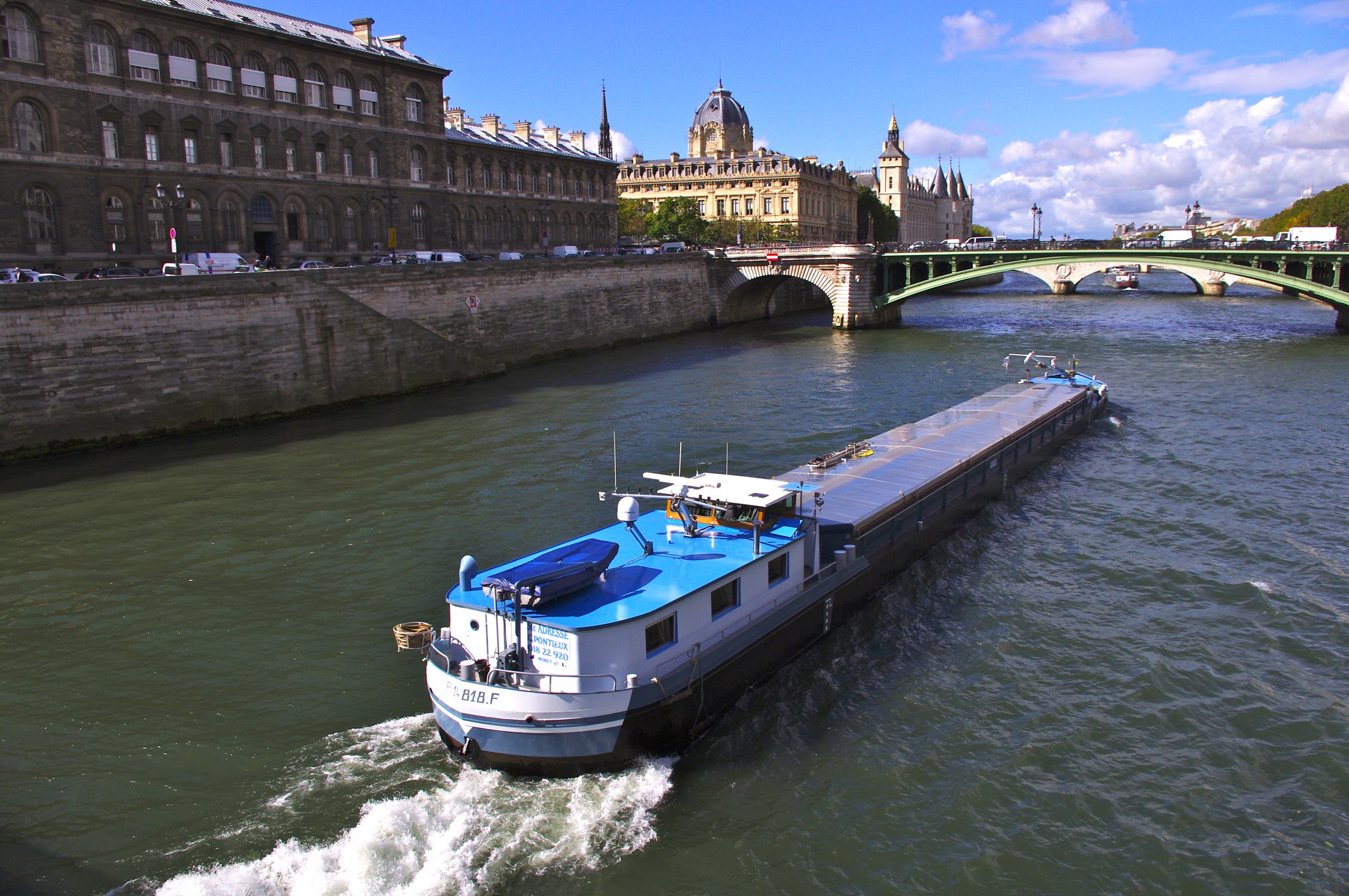 a large boat is on the water by a bridge