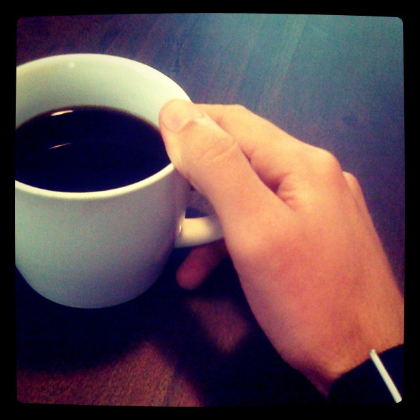 a cup of coffee being held by someone's hand