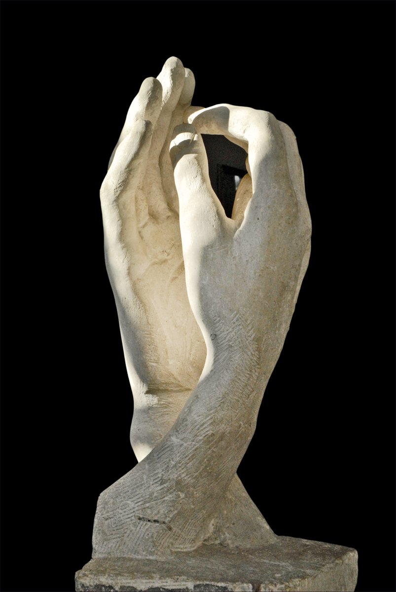 a sculpture of a hand holding soing against a black background