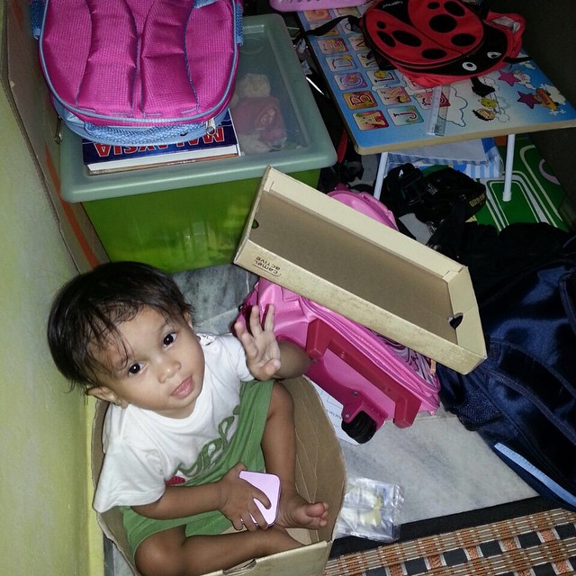 an asian child is sitting in a drawer with toys