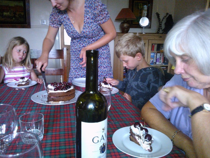 two adults, a child and a woman are at the table with desserts