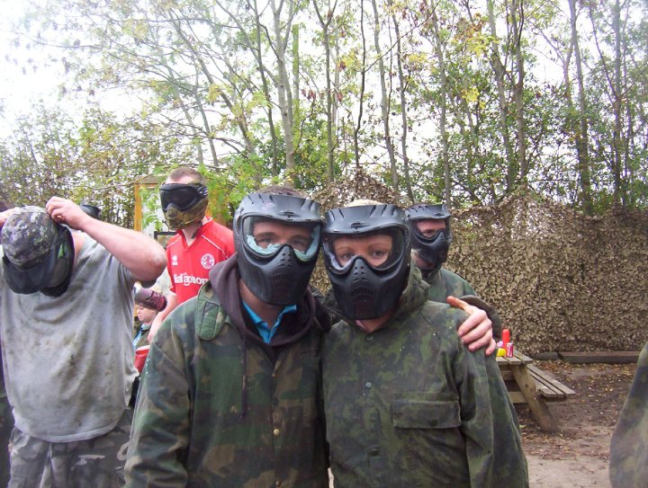 a couple of people wearing paintball helmets