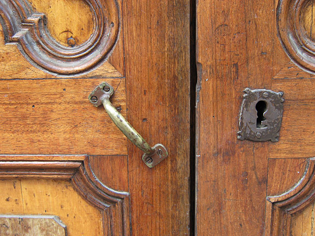 a wooden door with a fancy metal handle