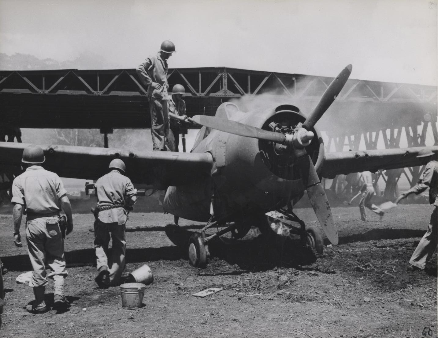 people standing around a large plane on top of a field