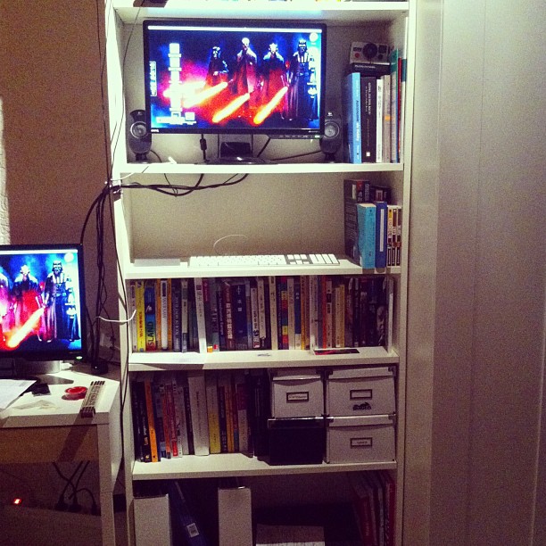 an entertainment center with two televisions and a laptop
