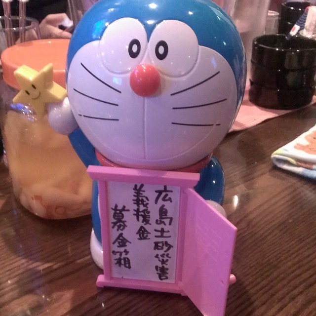 a figurine in the shape of a cat holding a sign