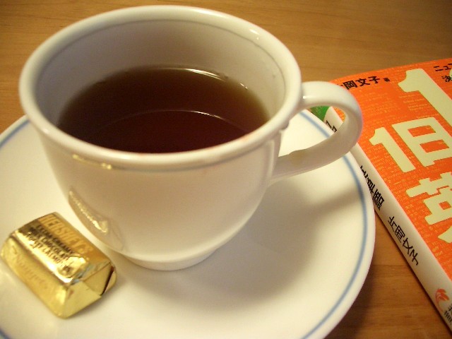 a cup of tea next to an orange book