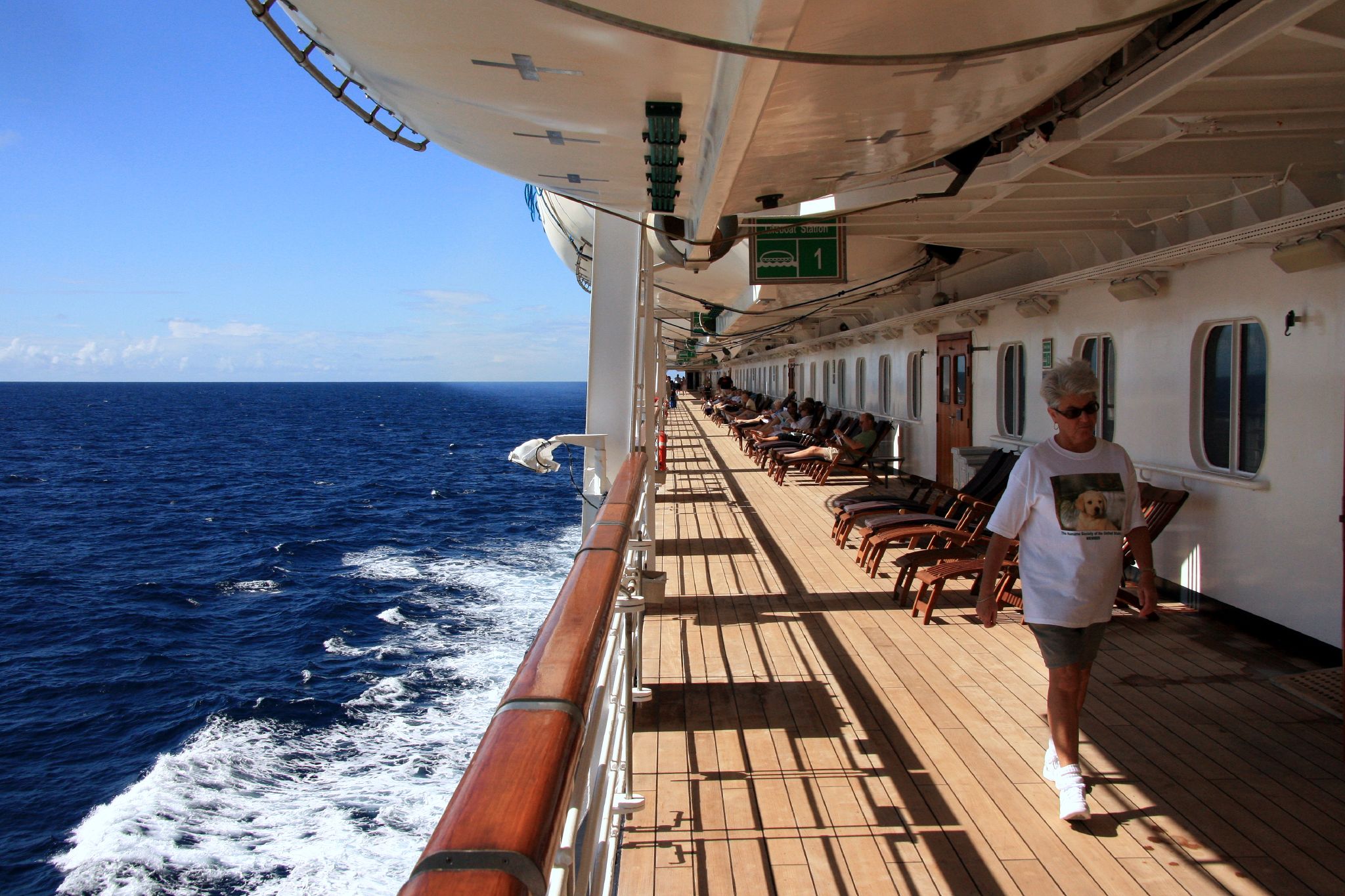 a person walks along a large line of chairs on a cruise ship