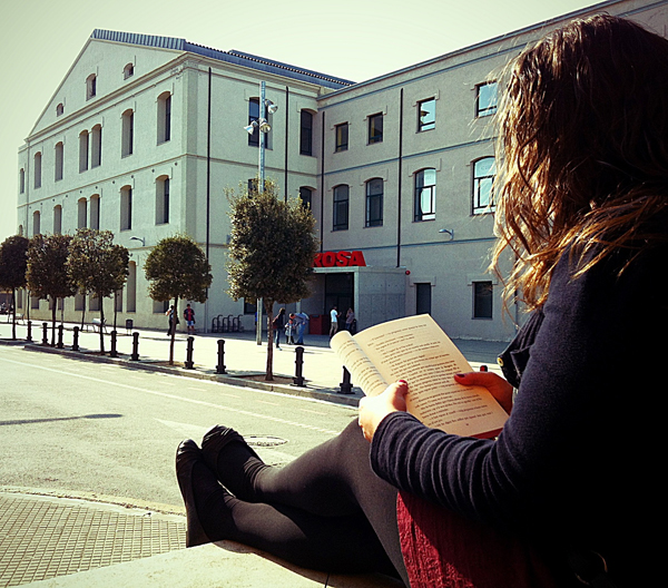 a girl is sitting down reading a book