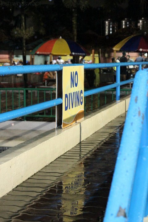 a no diving sign sits next to the water
