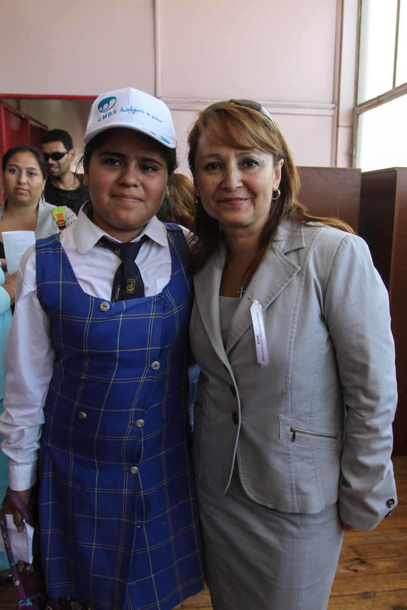 a woman posing for a po next to a lady with a hat