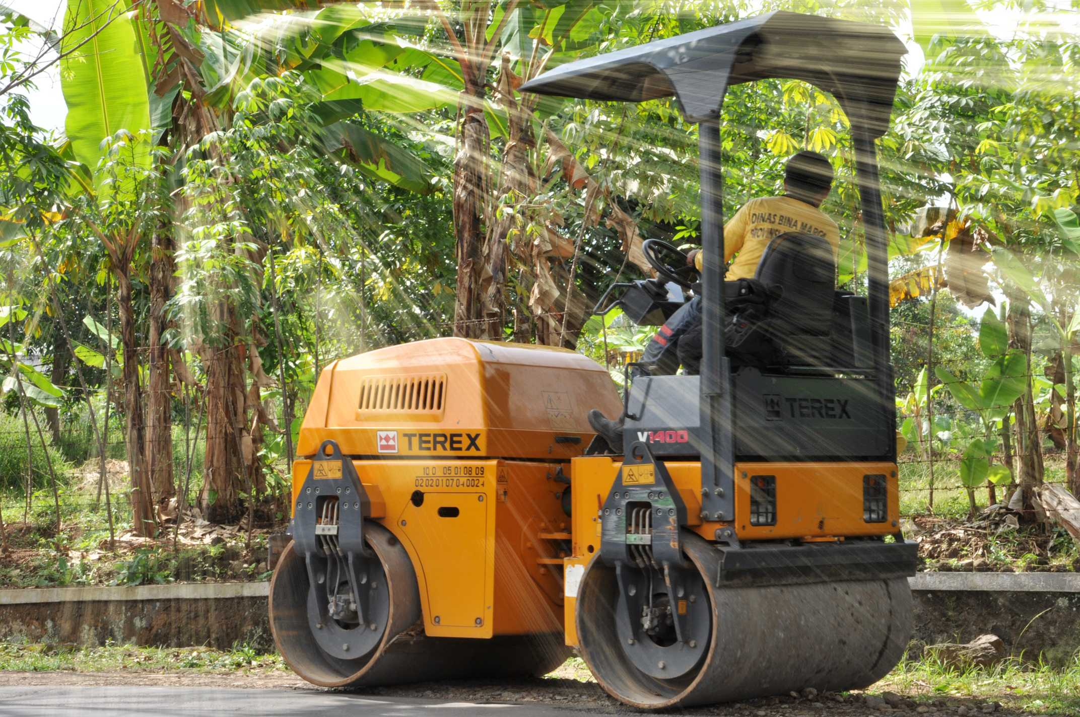 a man driving a wheeled forklift in the middle of a forest