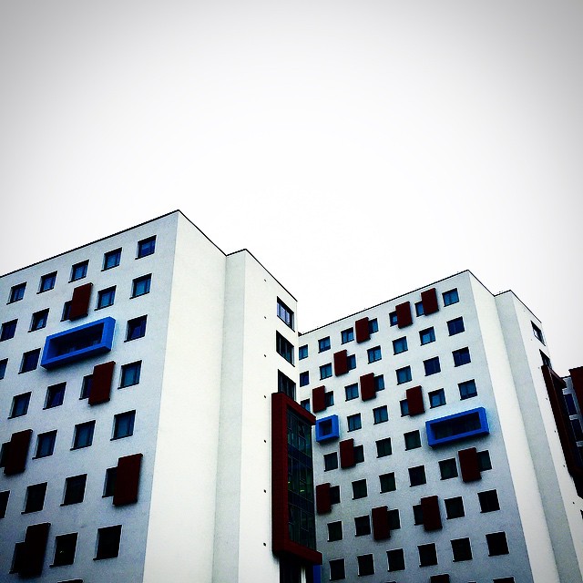 two tall buildings with blue windows in the middle of them