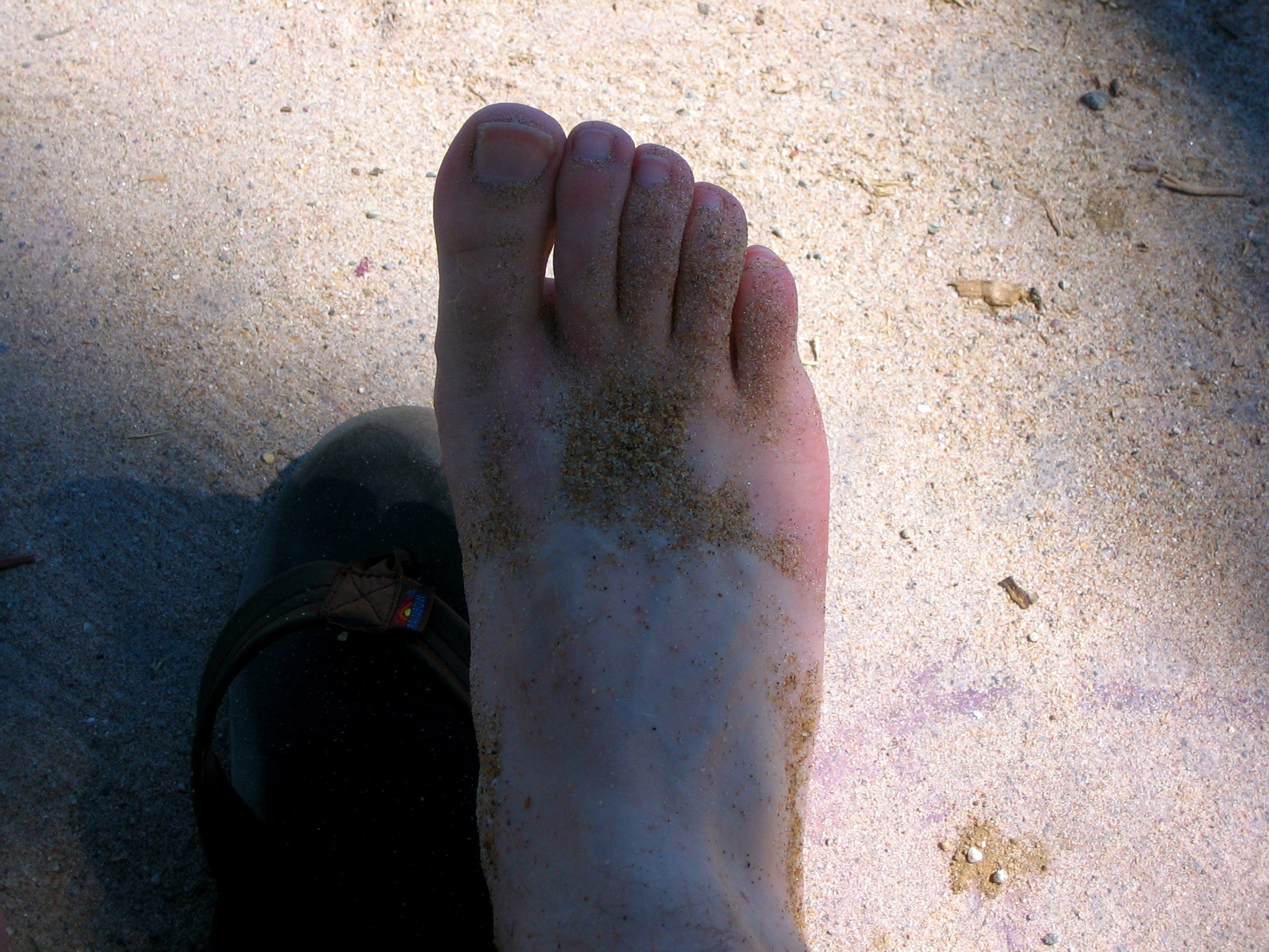 a person covered in dirt standing on a sidewalk