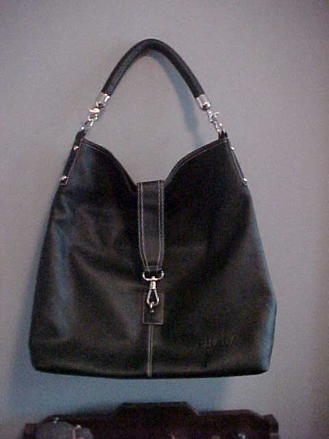 a black leather purse sitting on a shelf